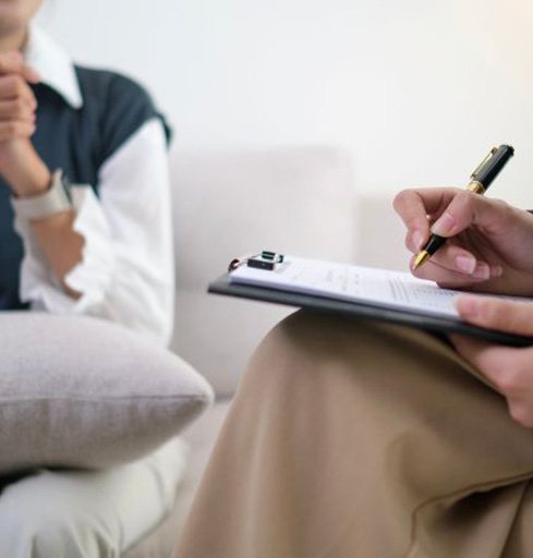 Therapist taking notes during talk therapy session