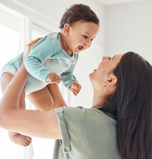 Happy mom playing with her baby