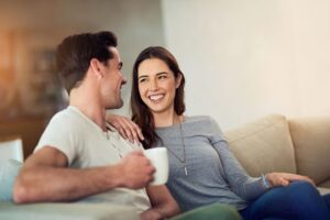 Husband and wife sitting on sofa, enjoying intimate conversation