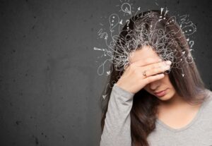 Woman holding her head, dealing with distracting thoughts